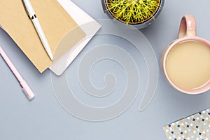 Flat lay home office desk. Female workspace with note book, eyeglasses, tea mug, diary, plant. Copy space