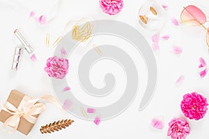 Flat lay home office desk. Pink rose flower buds, petals, female accessories, gift box on white background. Top view feminine