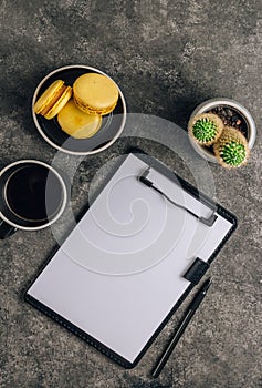 Flat lay of home office desk workspace with coffee,clipboard, macarons, flower on gray background. Trendy 2021 color