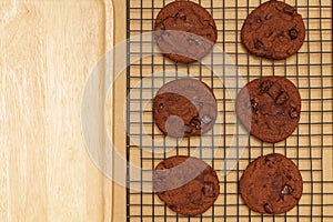 Flat lay of homemade sweets, Chocolate cookies on rack with wooden tray on wood background