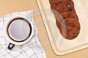 Flat lay of homemade sweets, Chocolate cookies are stack on plate and coffee over wood background