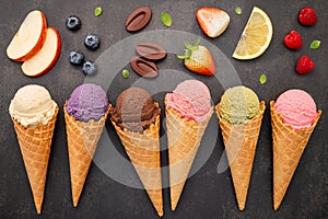 Flat lay ice cream cones collection on dark stone background . Blank crispy ice cream cone with copy space for sweets menu design