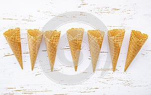 Flat lay ice cream cones collection on shabby wooden background . Blank crispy ice cream cone with copy space for sweets menu