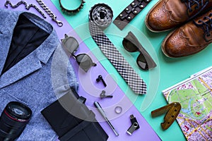 Flat lay image of accessory clothing man to plan travel in holiday background concept. lilac and turquoise background