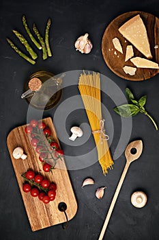 Flat lay of Ingredients for cooking italian pasta. Spaghetti, tomatoes, oil, garlic, parmezan
