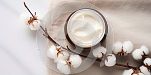 flat lay, a jar of face cream on a light background, cotton flowers.