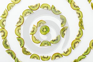 Flat lay with juicy cut kiwis on white surface.