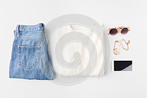 flat lay with knitted sweater, trendy jeans, accessories and smartphone,