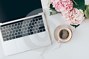 flat lay with laptop coffee cup and hortensia flowers