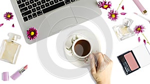 Flat lay with laptop, cup of tea, bottles of perfume, woman make u[ products and flowers