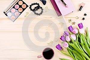 Flat lay with laptop, makeup items, tulip flowers, fashion accessories and stationery, modern woman office concept. Feminine