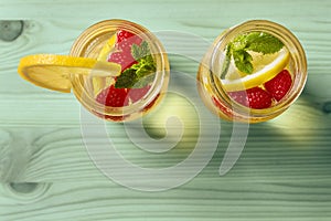 Flat lay of lemonade with berries on green wood