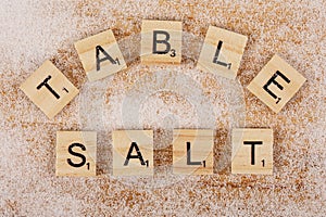 Flat Lay of Letters spelling Table Salt on wooded background