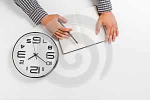 Flat lay with male hands with clock, notepad and pencil. businnes concept. white background