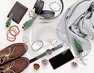 Flat lay of men's accessories with shoes, watch, phone, earphone