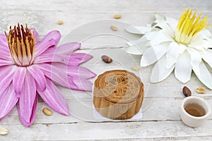 Flat lay of Mid Autumn festival Moon cake on old white table with pink water lily