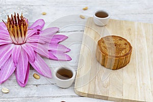 Flat lay of Mid Autumn festival Moon cake on old white table with pink water lily