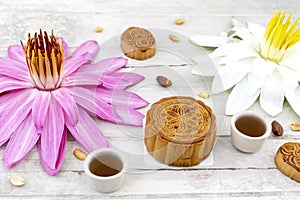 Flat lay of Mid Autumn festival Moon cake on old white table with pink water lily