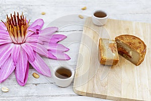 Flat lay of Mid Autumn festival Moon cake on old white table with pink water lily