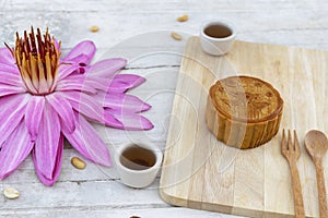 Flat lay of Mid Autumn festival Moon cake on old white table with pink water lily