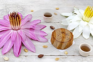 Flat lay of Mid Autumn festival Moon cake on old white table with pink water lily