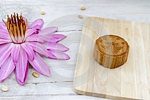 Flat lay of Mid Autumn festival Moon cake on old white table with pink water lily