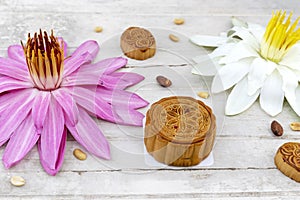 Flat lay of Mid Autumn festival Moon cake on old white table with pink water lily