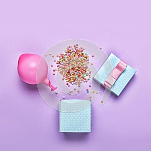 Flat lay.minimalism style, Blue gift box with various confetti parties, balloons, decorations on a green background. Colorful holi