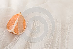 Flat lay modern abstract background white fabric and orange. Natural white texture in beautiful folds. Top view