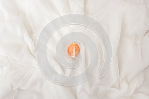 Flat lay modern abstract background white fabric and orange. Natural white texture in beautiful folds. Top view