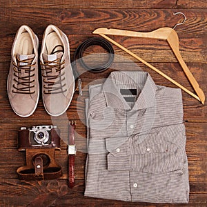 Flat lay of modern men`s clothing on a brown wooden background