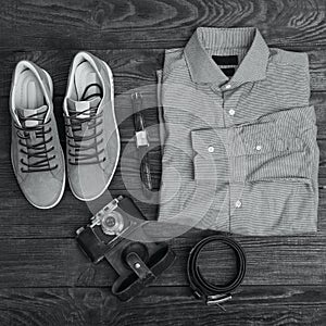 Flat lay of modern men`s clothing on a brown wooden background.