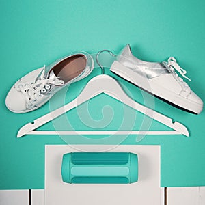 Flat Lay of Modern White Shoes. Overhead Top View Photography. Youth Lifestyle Concept. Turquoise background