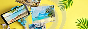 Flat lay monopod with a smartphone and photos on a yellow background Travel concept Banner