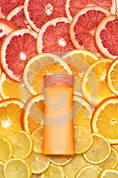 Flat lay of natural vitamin C skincare product isolated over fresh juicy orange citrus fruit slice background