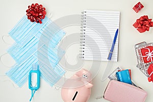 Flat lay with notebook, Christmas tree made from medical masks and sanitiser on white background