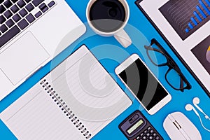 Flat lay Office desk table of modern workplace with laptop on blue table, top view laptop background and copy space on black