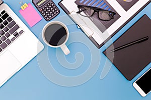Flat lay Office desk table of modern workplace with laptop on blue table, top view laptop background and copy space on black