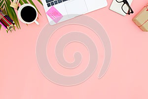 Flat lay office workspace with blank laptop, clipboard, eucalyptus branches on pink background. top view laptop background and