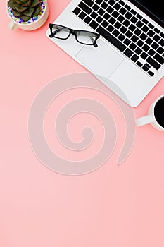 Flat lay office workspace with blank laptop, clipboard, eucalyptus branches on pink background. top view laptop background and