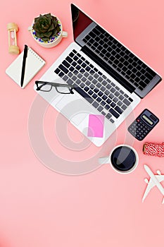 Flat lay office workspace with blank laptop, clipboard, eucalyptus branches on pink background. top view laptop background and