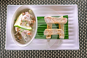 Flat lay of Oka - known as kokoda, poke, ceviche, or poisson cru - is Polynesian raw fish salad from Samoa, with taro chips