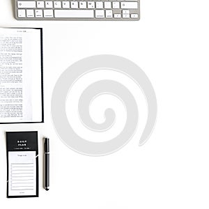 Flat lay: open Bible, book, keyboard, to do list, on white background and pink, purple, violette, red Gerbera flower with petals photo