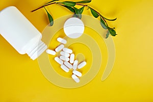 Flat lay Organic medical pills with herbal plant on a yellow background