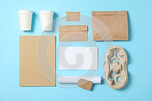 Flat lay. Paper cups and office supplies on blue background