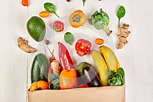 Flat lay paper shopping bag with assortment of fresh vegetables and fruits