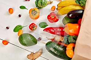 Flat lay paper shopping bag with assortment of fresh vegetables and fruits