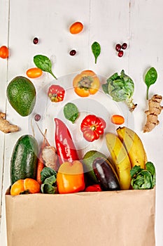 Flat lay paper shopping bag with assortment of fresh vegetables and fruits