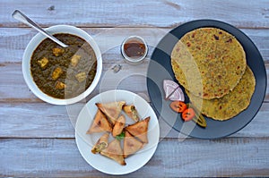 Flat lay of Paratha flatbread Indian cuisine served with traditional Punjabi Palak Paneer dish