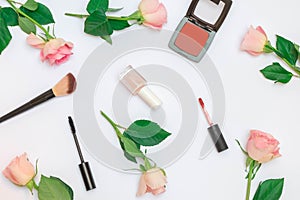 Flat lay pastel pink composition with decorative cosmetics and roses